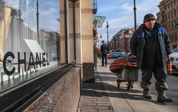 Чоловік з візком біля вітрини преміум-бренду Chanel під час кризи в Росії