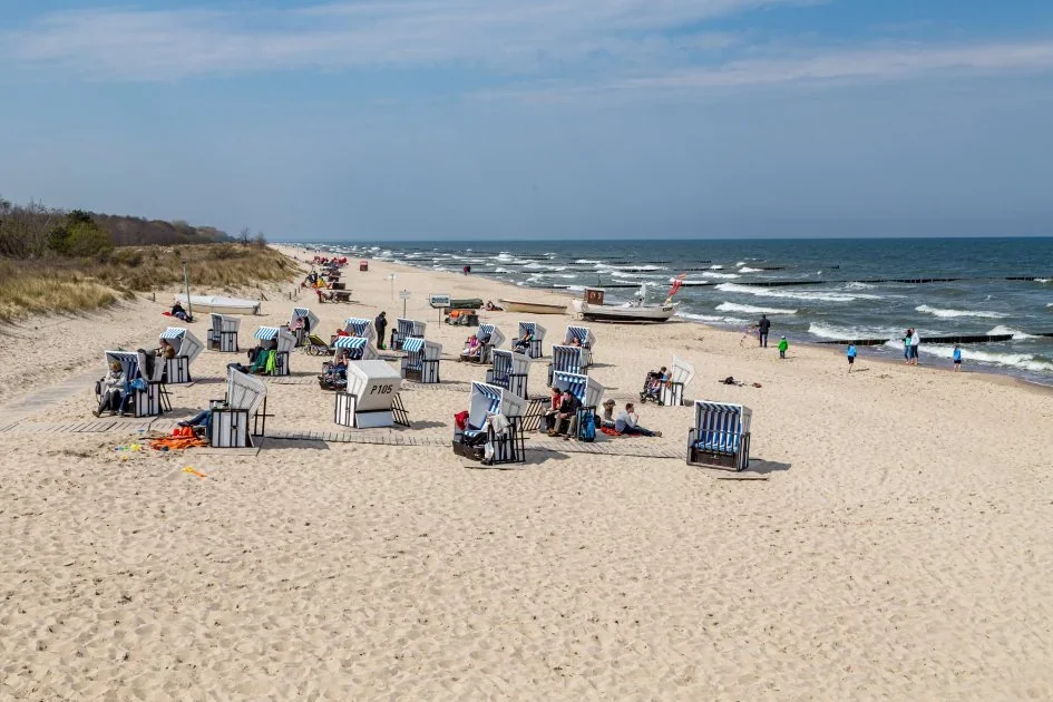 Німецький пляж з традиційними Strandkörbe та відвідувачами біля моря
