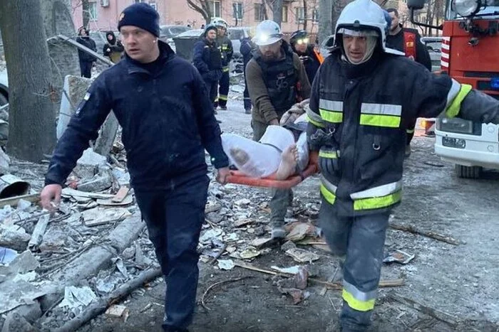 Рятувальники несуть тіло з-під завалів багатоповерхівки в Запоріжжі