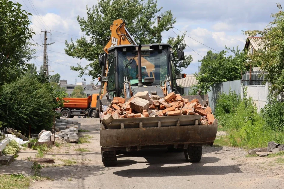 Екскаватор навантажує цеглу з руїн під час відбудови Вишневого
