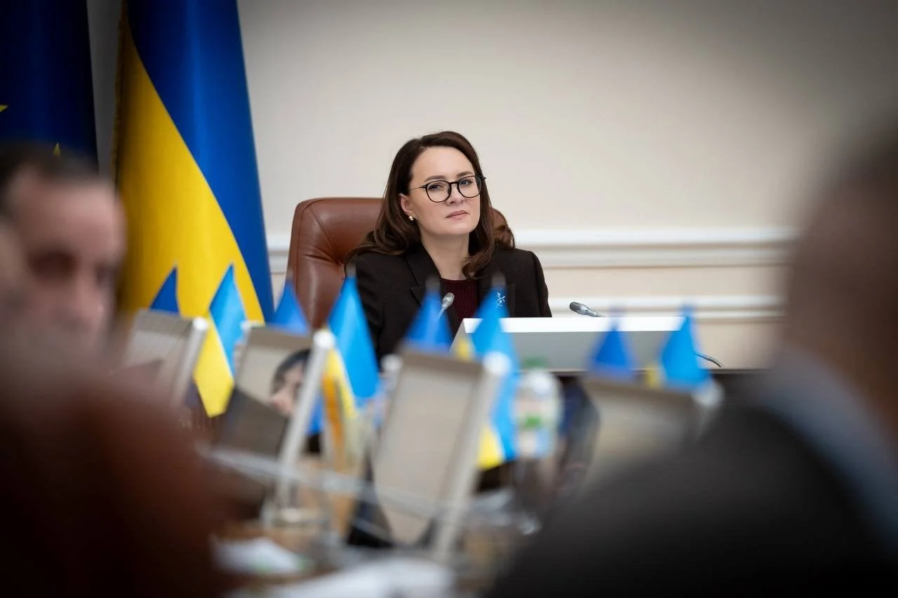 Женщина за столом президиума Верховной Рады с украинскими флагами