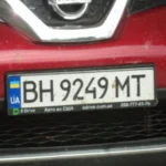 Передня частина червоного Nissan з українським номером BH 9249 MT