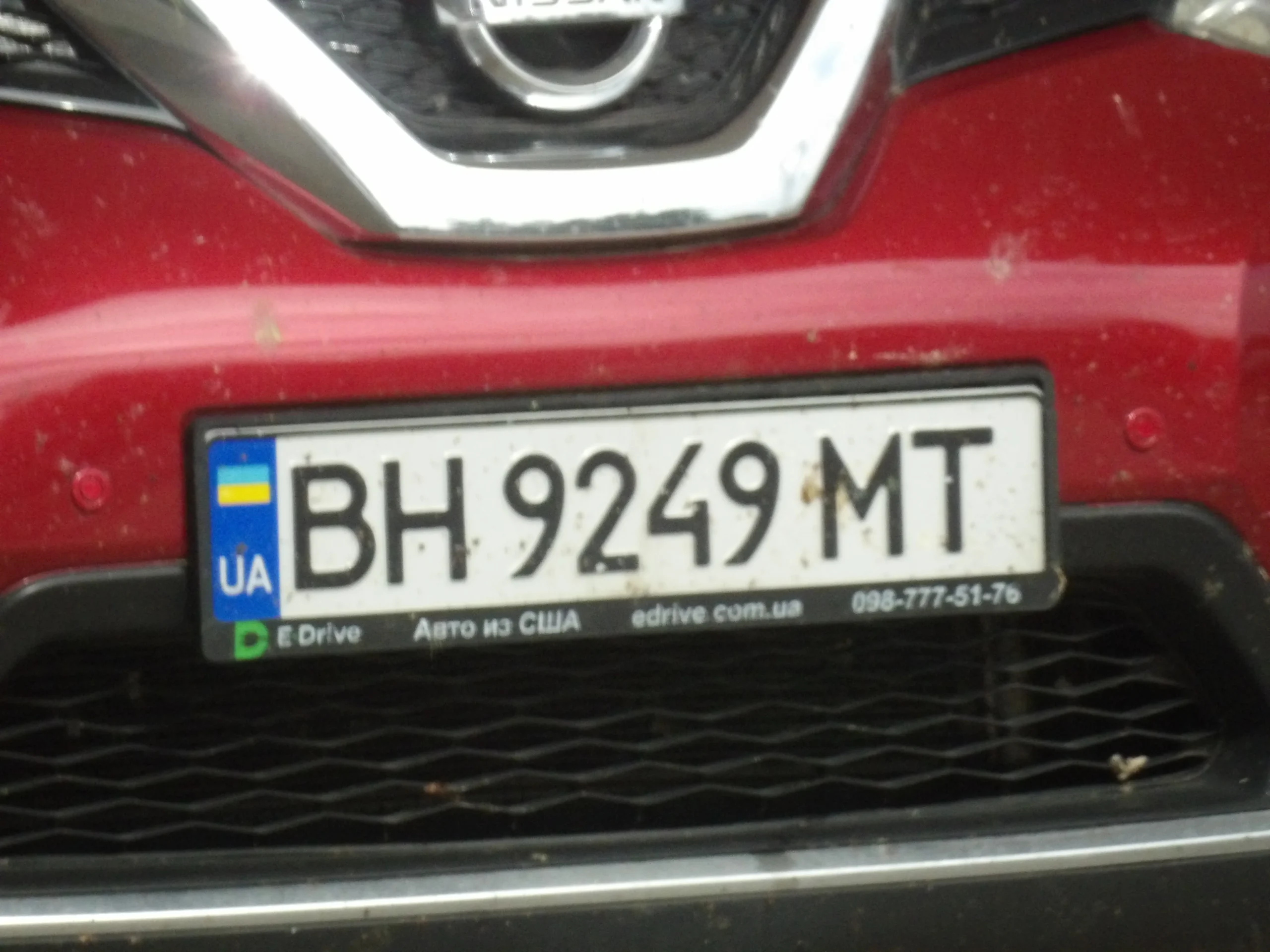 Передня частина червоного Nissan з українським номером BH 9249 MT